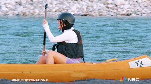 a woman in a yellow kayak with a white x on the side