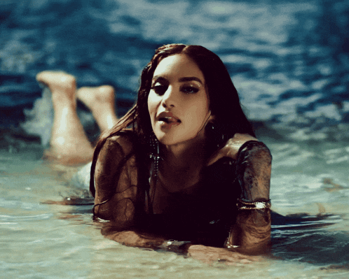 a woman laying in the water with her feet up