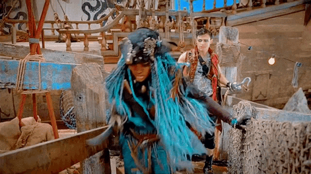 a woman with blue hair is standing next to a man on a boat .