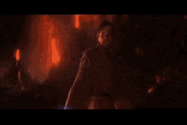 a man is holding a light saber in a dark room