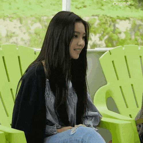 a woman is sitting in a green chair with the word original on the bottom right