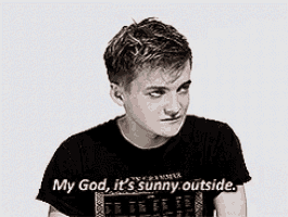 a young man wearing a black shirt says my god it 's sunny outside .