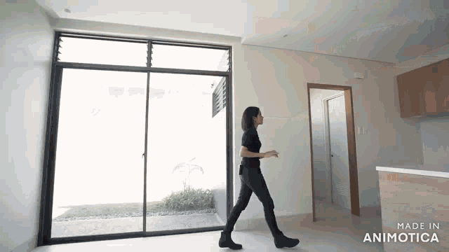 a woman is walking through an empty room with the words made in animotica on the bottom