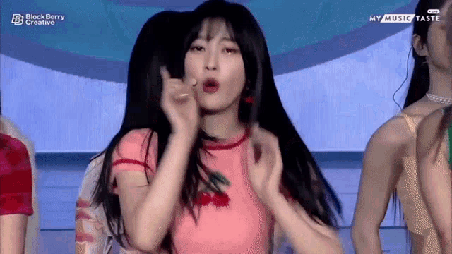 a woman in a pink shirt is dancing on a stage .