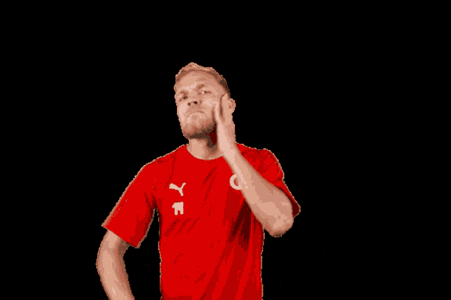 a man wearing a red shirt with the number 14 on the front
