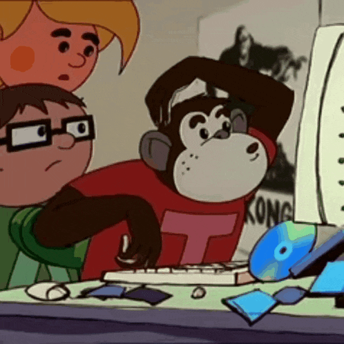 a cartoon monkey wearing a kong shirt is looking at a computer screen
