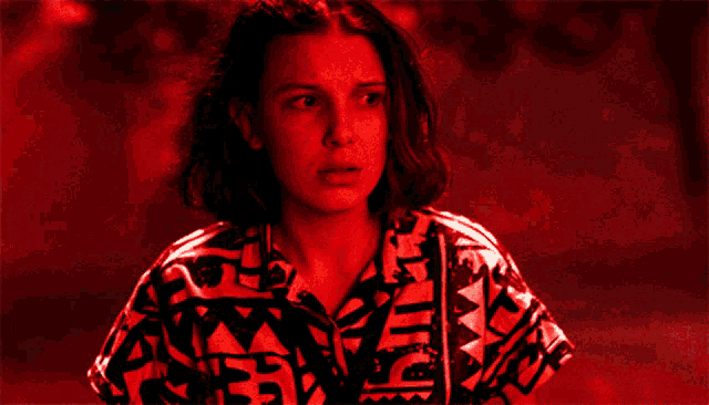 a close up of a woman 's face with a red background and a shirt that says adidas on it