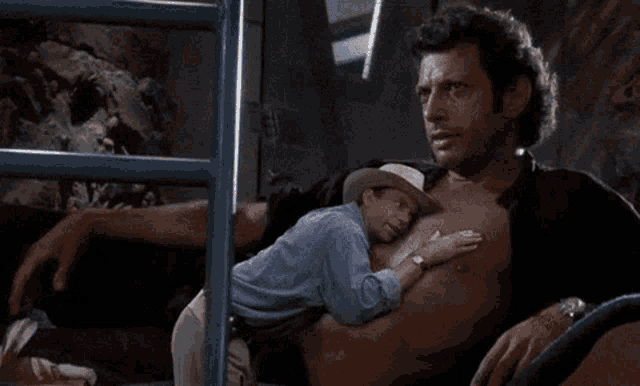 a man in a cowboy hat is holding another man 's chest .