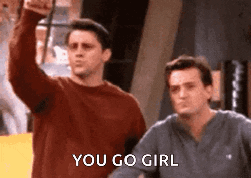 two men are standing next to each other and one of them is holding up his fist and says `` you go girl '' .