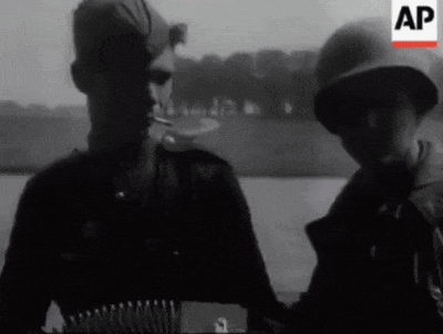 a man smoking a cigarette next to another man holding an accordion