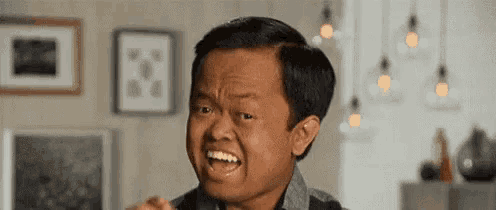 a very small man is making a funny face in a living room with his mouth open .