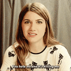 a woman is wearing a sweater with cats on it and says `` you hate me and it 's killing me ''