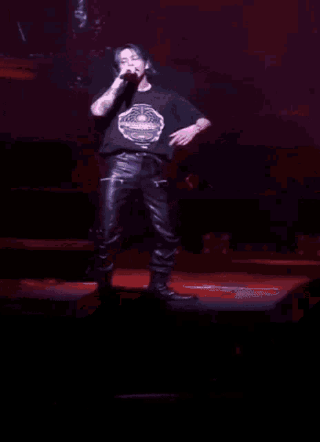 a man singing into a microphone with a purple background