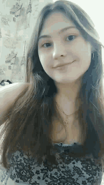 a young girl is taking a selfie with a cross necklace .