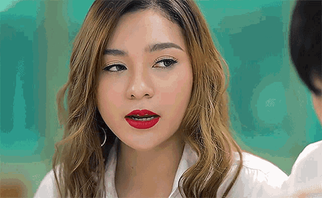 a close up of a woman 's face with red lipstick on her lips
