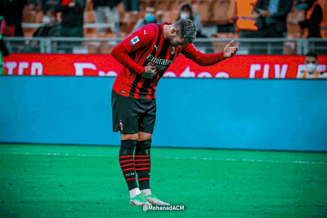 a soccer player wearing a jersey that says emirates on it