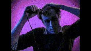 a man is looking through binoculars on a pink background .