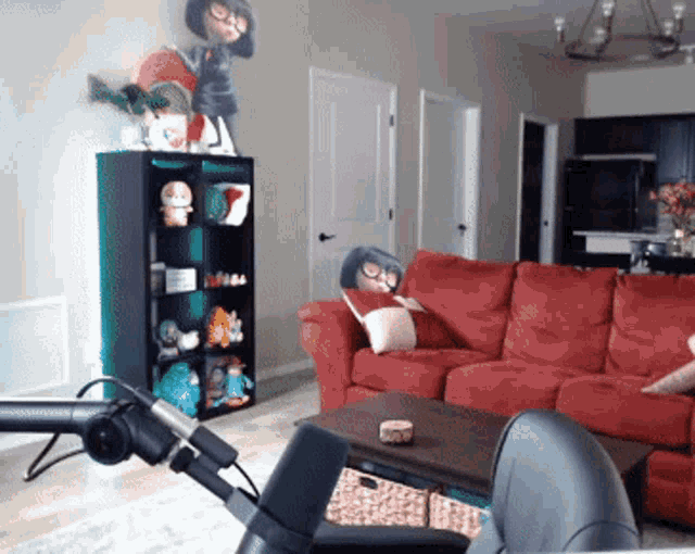 a living room with a red couch and a green shelf with stuffed animals on it