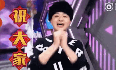 a man wearing a black hat and a black shirt with chinese writing on it