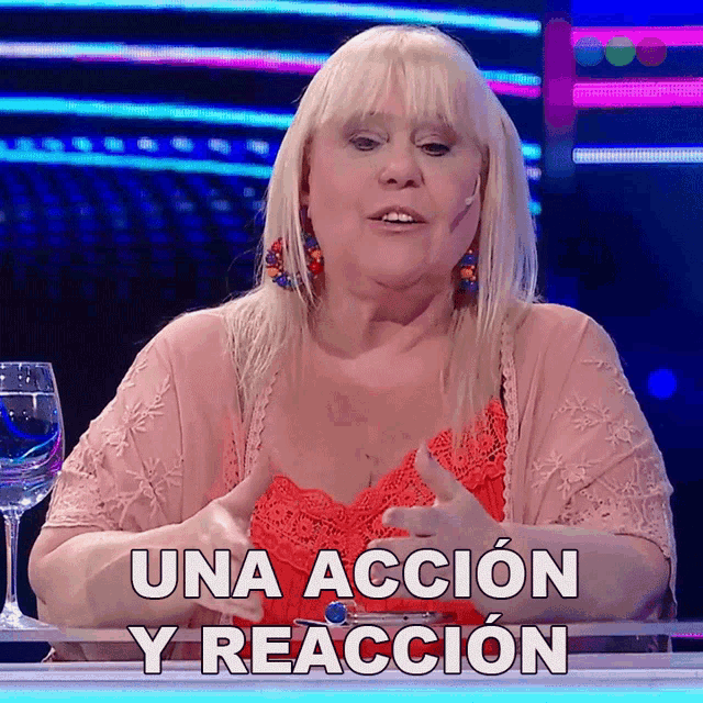 a woman sitting at a table with the words una accion y reaccion written above her