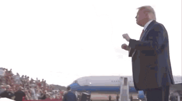a man in a suit and tie is standing in front of a united states air force one plane .