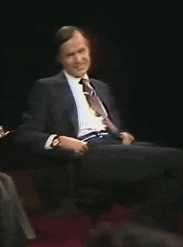 a man in a suit and tie is sitting on a chair