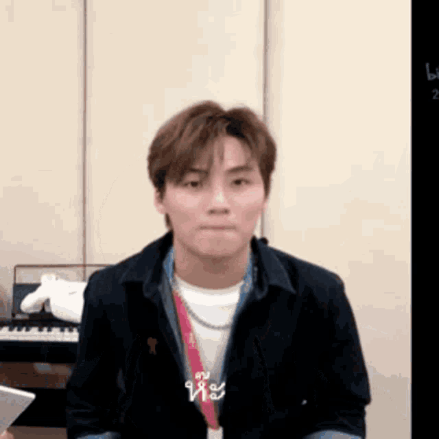 a man is sitting in front of a keyboard and making a face