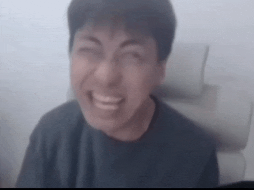 a blurry picture of a man making a funny face with his mouth open .