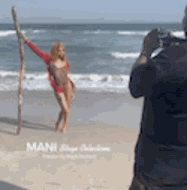 a man taking a picture of a woman on the beach