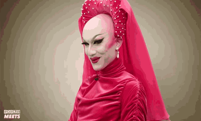 a drag queen wearing a red dress and veil with the word meets on the bottom