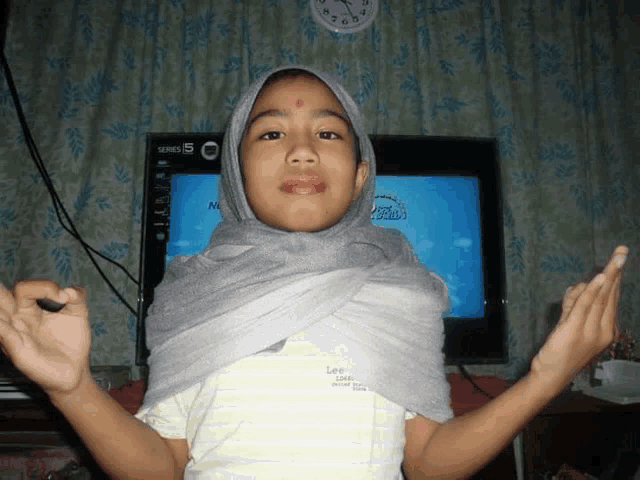a little girl wearing a hijab and a lee shirt