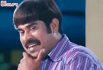 a man with a mustache and a striped shirt is smiling and touching his chin .