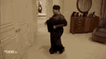 a man is standing in a hallway talking to a woman .