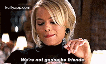 a woman in a black turtleneck is eating a piece of food and saying `` we 're not gonna be friends '' .