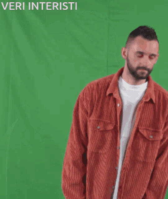 a man in a red jacket is standing in front of a green screen with the words veri interisti written above him