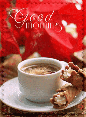 a cup of coffee sits on a saucer next to two cannoli with whipped cream on them