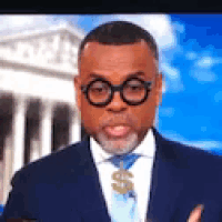 a man wearing a suit and tie with a dollar sign on his tie