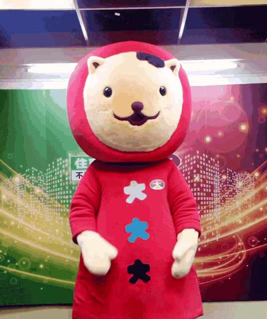 a stuffed animal in a red costume with chinese characters on its chest