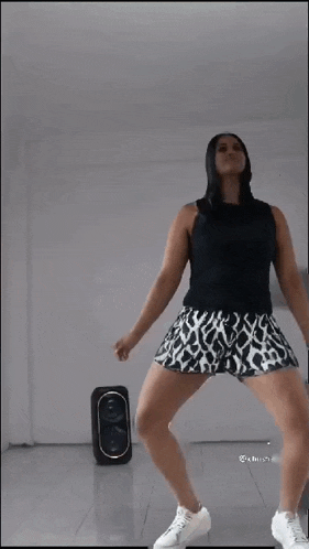 a woman is dancing in front of a speaker .