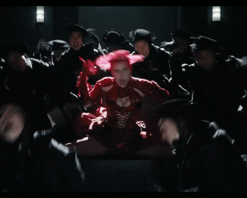 a blurred image of a crowd of people sitting in a dark room