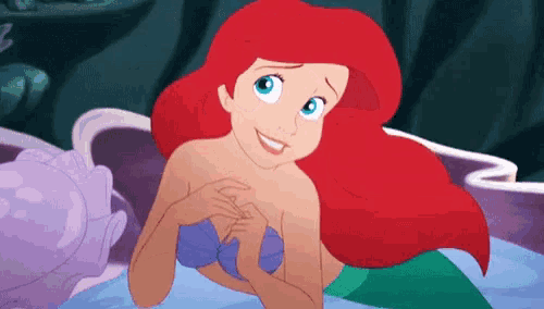 ariel from the little mermaid is smiling and looking at the camera