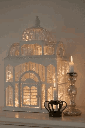 a white bird cage with a candle in it