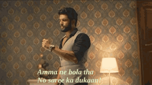 a man stands in front of a wall with the words amma ne bola tha no saree ka dukaan written on it