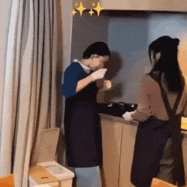a man and a woman are standing in a kitchen .