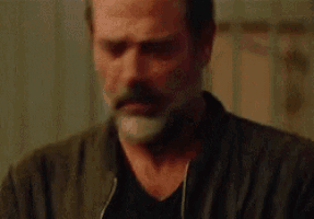 a man with a beard and mustache is wearing a black jacket and a black shirt .