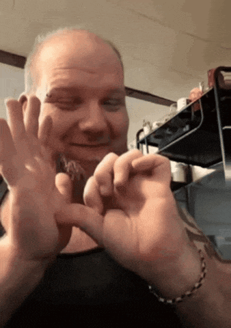 a man with a tattoo on his arm is holding a small object in his hands