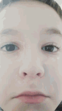 a close up of a person 's face with a serious look on his face