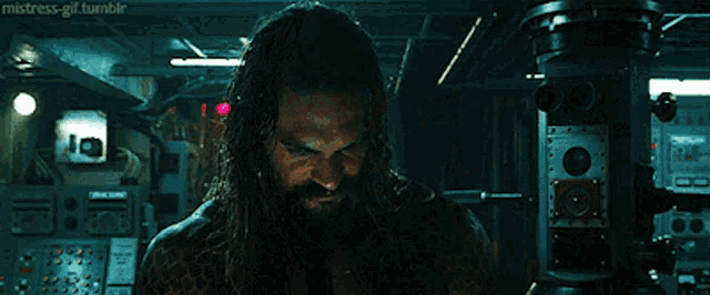 a man with long hair and a beard is standing in a dark room with the words " mistress-gif.tumblr " above him