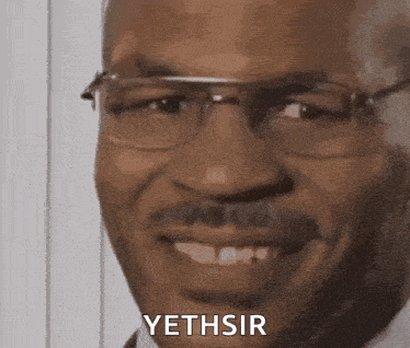 a close up of a man wearing glasses and a mustache smiling and saying yethsir .
