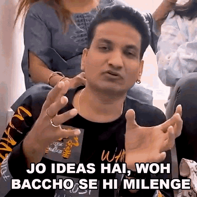 a man is sitting in a room with his hands outstretched and says jo ideas hai , woh baccha se hi milenge .